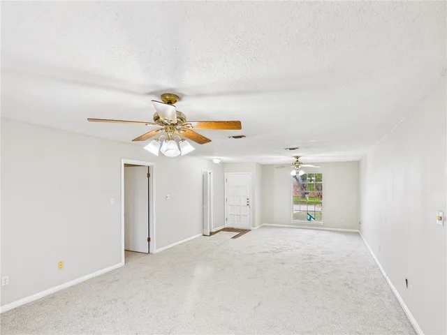 a view of a bedroom with a ceiling fan and window