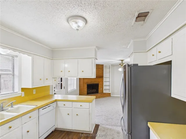 a kitchen with a refrigerator sink and cabinets