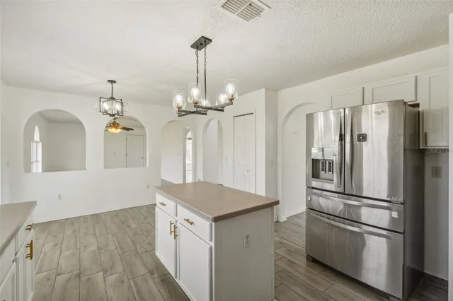 a kitchen with stainless steel appliances granite countertop a refrigerator a stove and a wooden floors