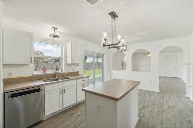 a kitchen with a sink chandelier and stove