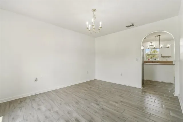 wooden floor in a room with a chandelier