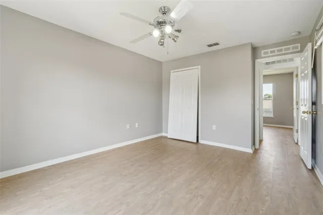 a view of a room with wooden floor and a ceiling fan