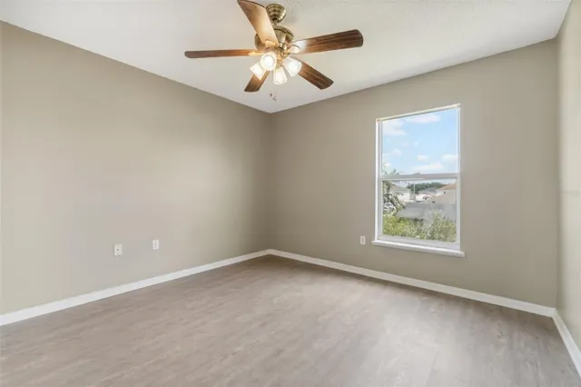 an empty room with a window and a fan