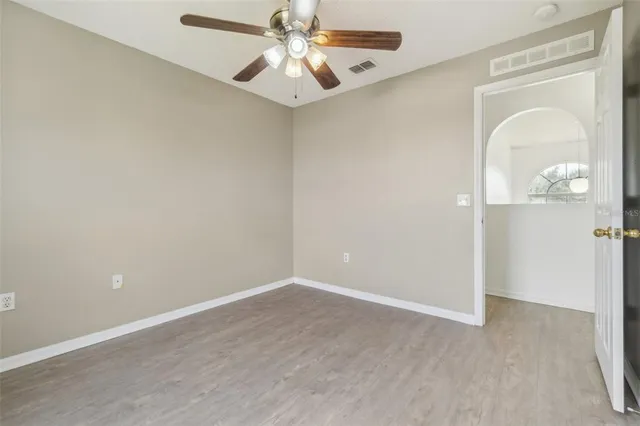 an empty room with a mirror and a fan