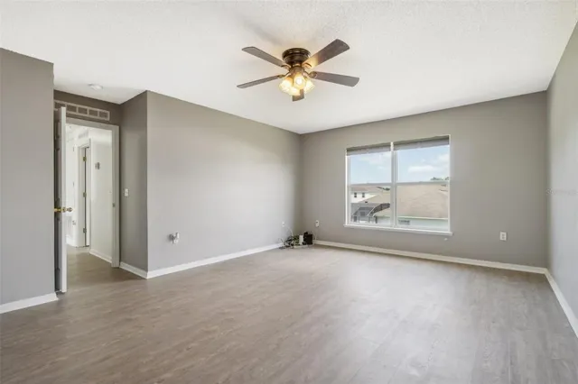 an empty room with fan and windows