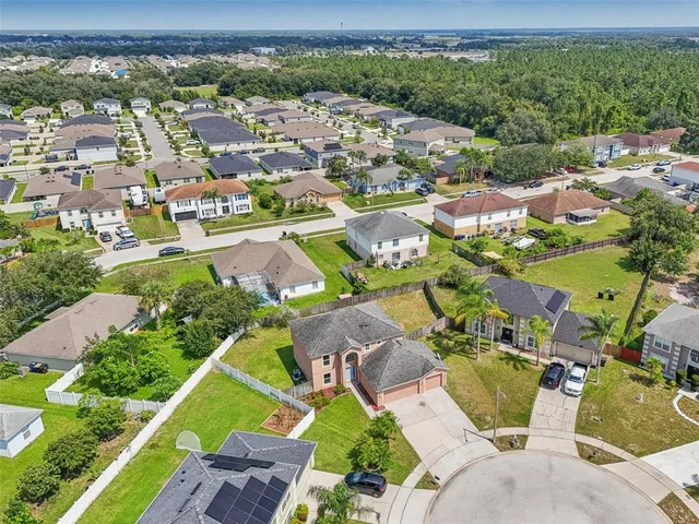 an aerial view of residential houses with outdoor space and parking