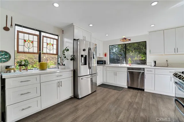 a kitchen with white cabinets and white appliances