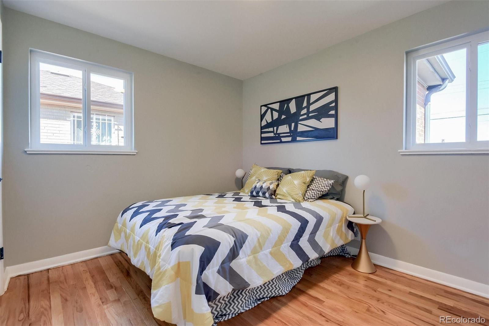 3014 Magnolia Street Denver, CO 80207 - Photo 12 of 16 a bedroom with a bed and wooden floor