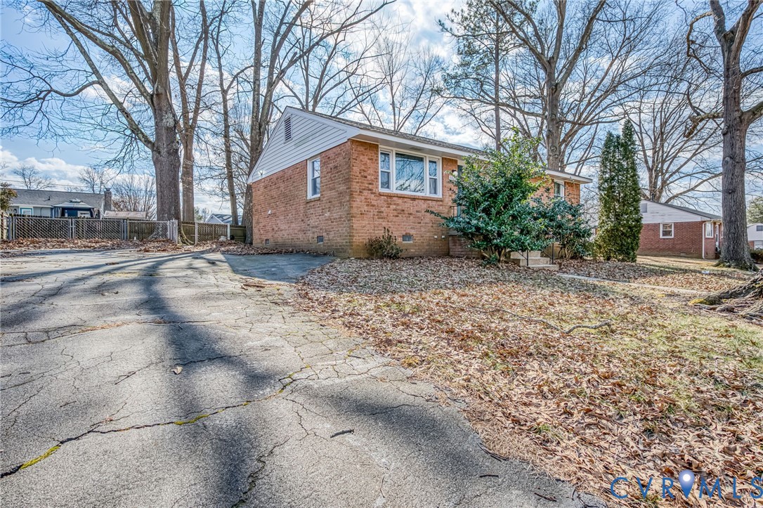 3029 Gaffney Road Richmond, VA 23237 - Photo 16 of 21 a backyard of a house with large trees and covered by side of it