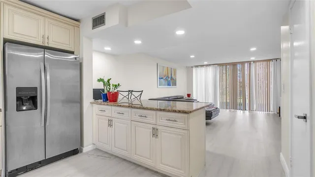 a kitchen with granite countertop a refrigerator and a sink