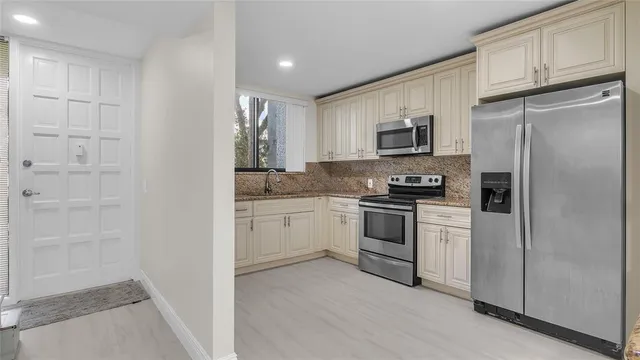 a kitchen with white cabinets and stainless steel appliances