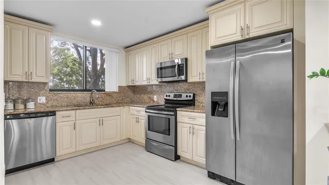a kitchen with stainless steel appliances granite countertop a refrigerator sink and microwave