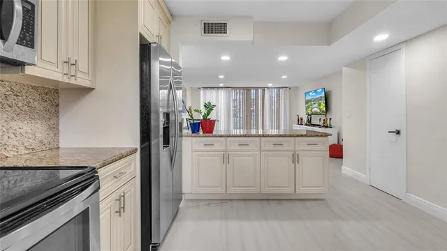 a kitchen with white cabinets and counter space