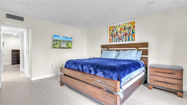 a bedroom with a bed and painting on the wall