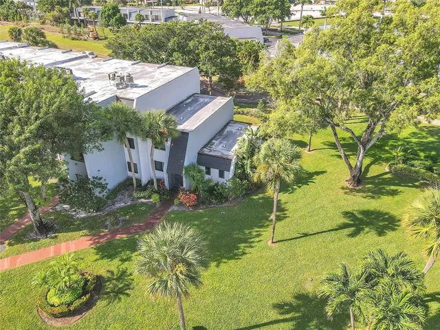 a aerial view of a house with a yard and large trees