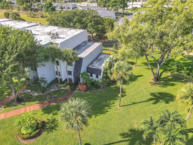 a aerial view of a house with a yard and large trees
