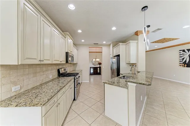 a kitchen with stainless steel appliances granite countertop a sink refrigerator and cabinets