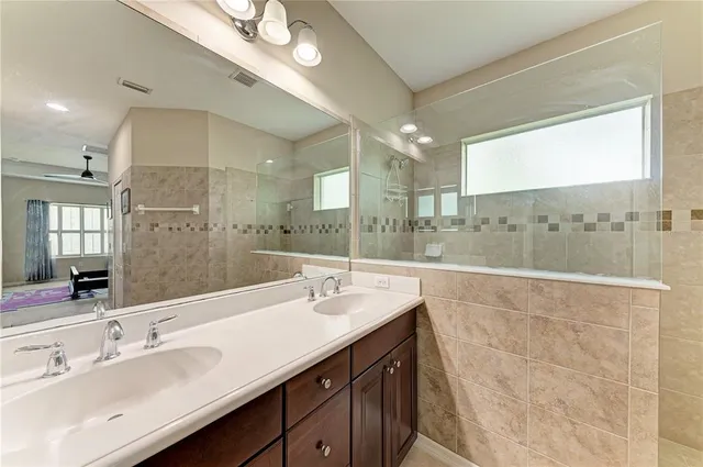 a bathroom with a double vanity sink mirror and shower