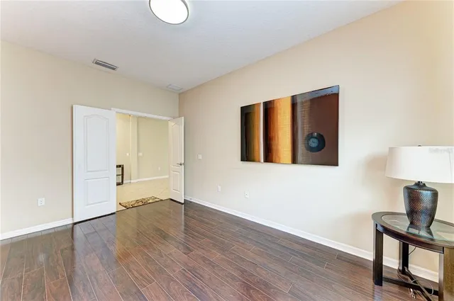 a view of an empty room with wooden floor and a cabinet