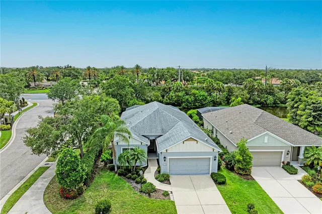 an aerial view of a house with a yard and lake view