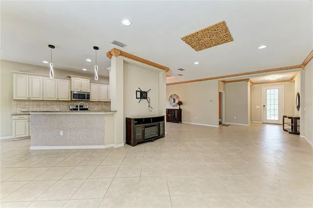 a large white kitchen with stainless steel appliances granite countertop a stove a sink a refrigerator and white cabinets with wooden floor