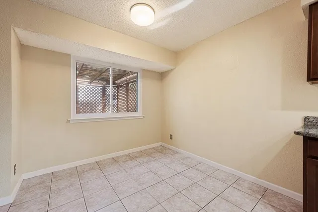 an empty room with windows and fireplace