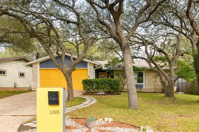 a yellow house with trees in front of it
