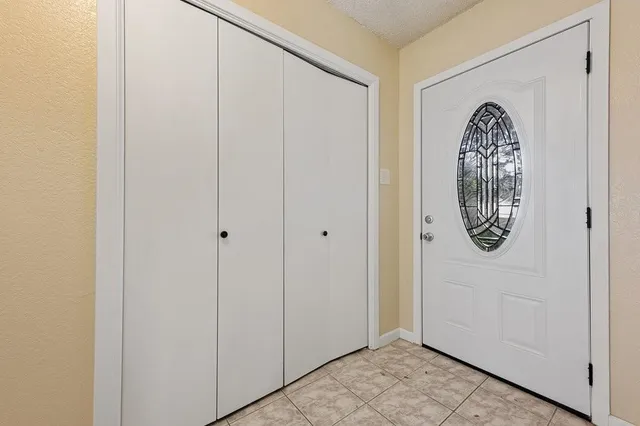 a view of an empty room with wooden floor fireplace and a window