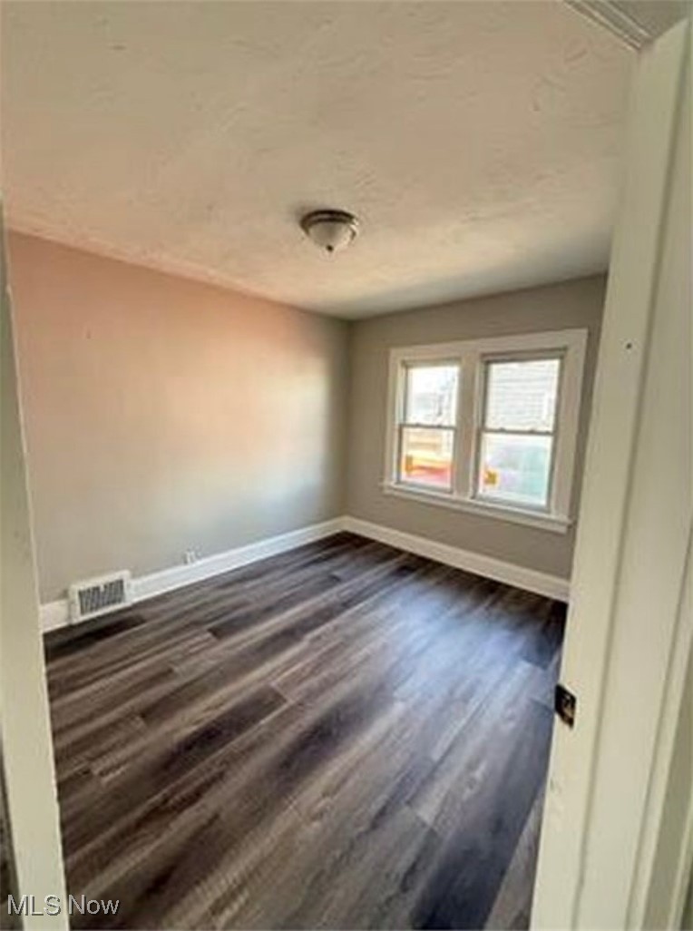 1743 Algonac Road Cleveland, OH 44112 - Photo 18 of 19 Spare room featuring dark wood-style floors and baseboards