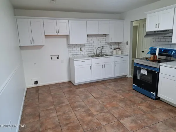 a kitchen with a stove a sink and a refrigerator