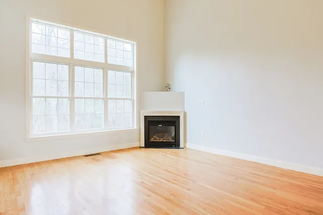 an empty room with wooden floor and a window