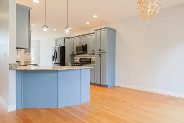 a kitchen with kitchen island a sink stainless steel appliances and cabinets