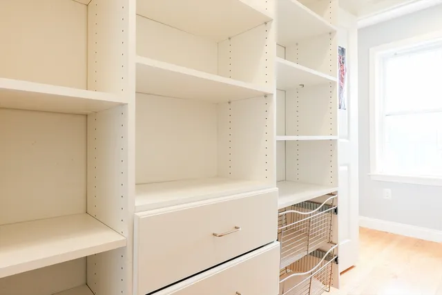a view of walk in closet with empty racks