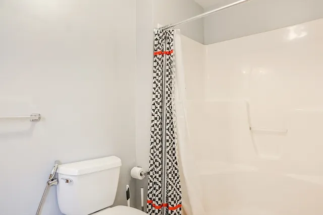 a bathroom with a toilet and a shower