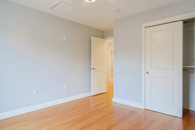 a view of an empty room with wooden floor