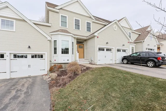 a view of a white house with a large space in front of it