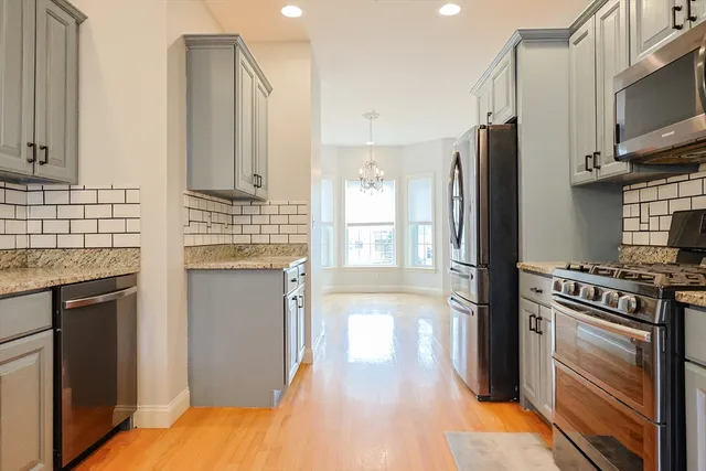 a kitchen with stainless steel appliances granite countertop a refrigerator a stove and a sink