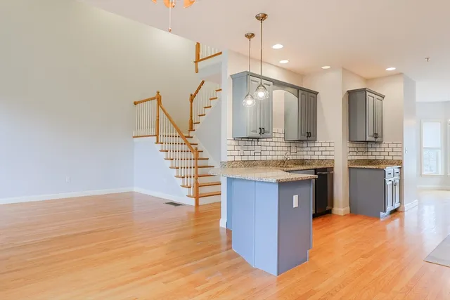 a kitchen with kitchen island a counter top space appliances and a ceiling fan