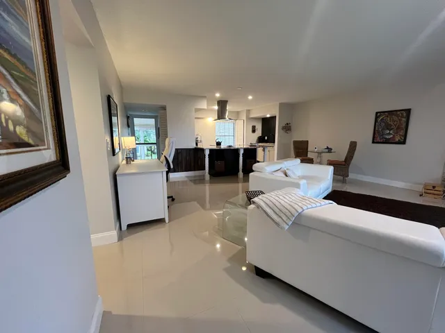 a living room with stainless steel appliances kitchen island granite countertop furniture and a view of kitchen