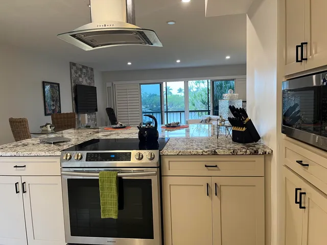 a kitchen with stainless steel appliances kitchen island granite countertop a stove and a sink