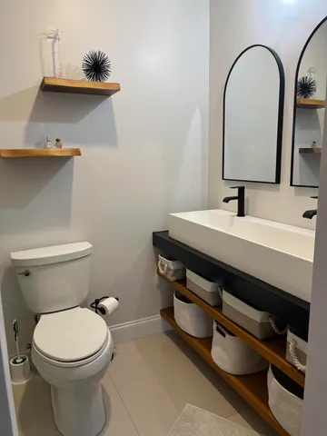 a bathroom with a toilet sink and mirror