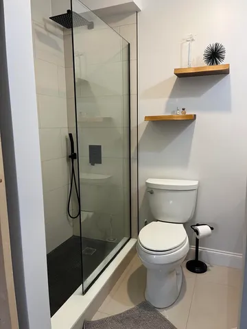 a bathroom with a toilet and a shower