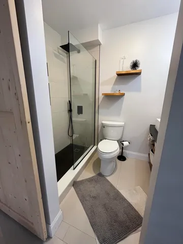 a bedroom with a bed and a flat tv screen on dresser