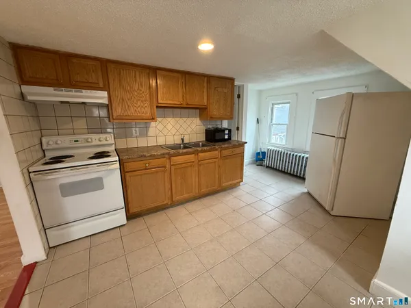 a kitchen with a stove a sink dishwasher a refrigerator and cabinets