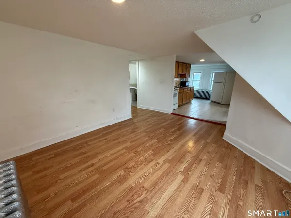a view of empty room with wooden floor