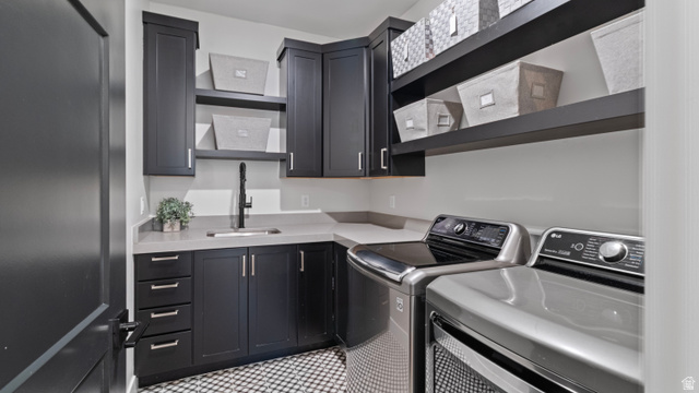 355 East Overlook Loop Hideout, UT 84036 - Photo 25 of 40 Main level utility room featuring dark cabinetry, light countertops, a utility sink with a matte black faucet, and patterned floor tiling. Plumbed for both gas and electric.
