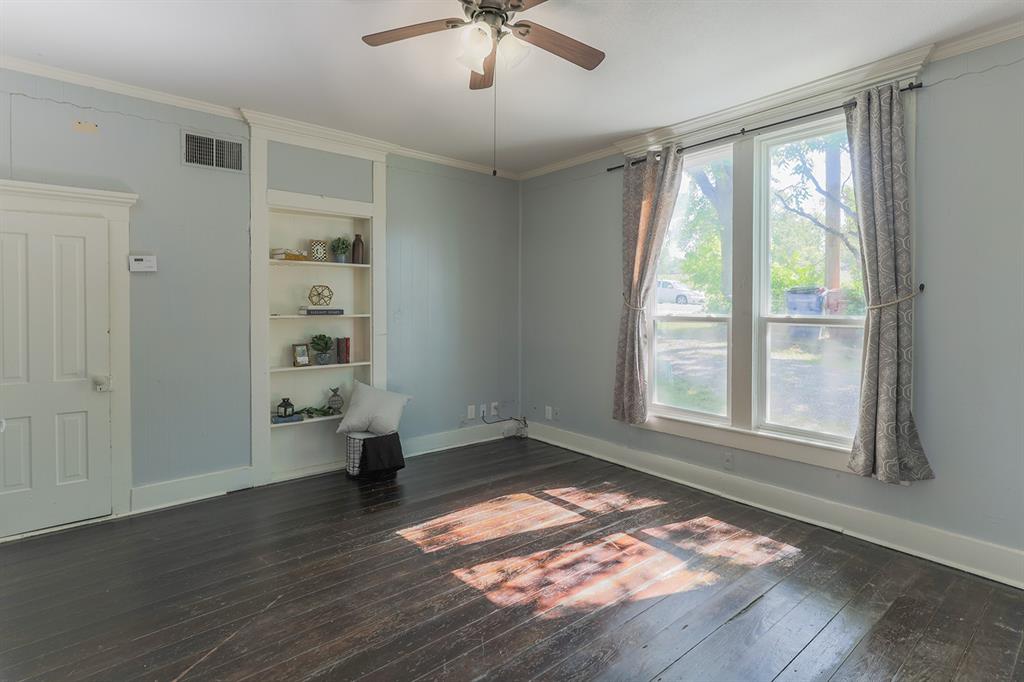 453 East Marshall Street Van Alstyne, TX 75495 - Photo 9 of 30 an empty room with wooden floor fan and windows