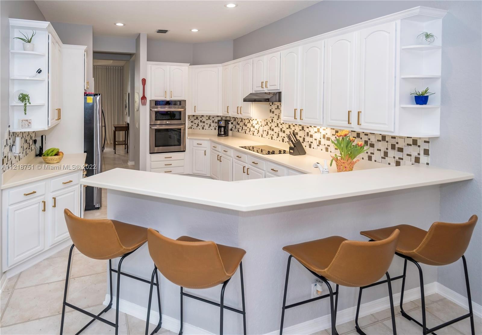 21432 Gosier Way Boca Raton, FL 33428 - Photo 12 of 55 a kitchen with stainless steel appliances kitchen island granite countertop a table and chairs