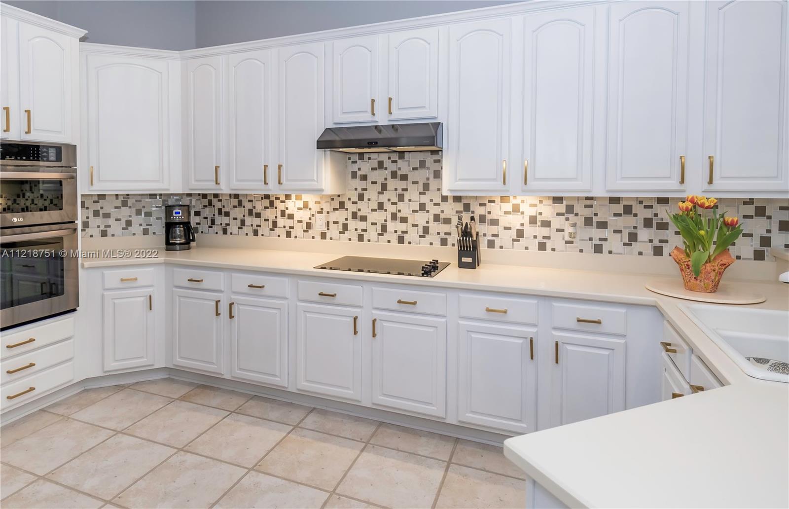 21432 Gosier Way Boca Raton, FL 33428 - Photo 13 of 55 a kitchen with white cabinets and sink