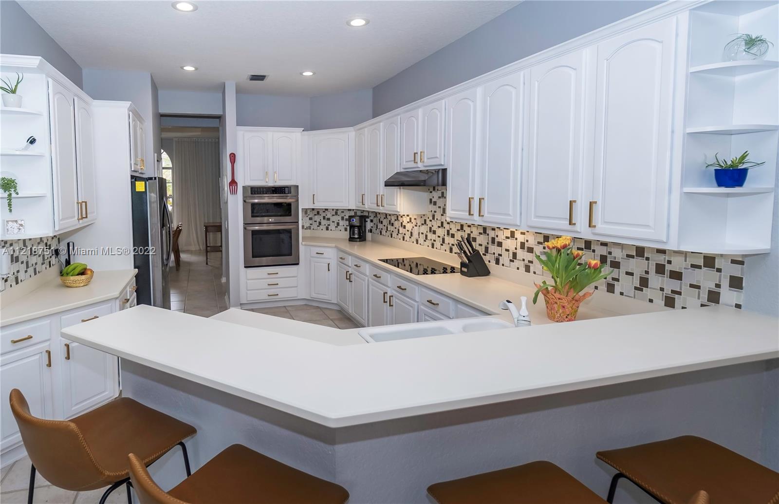21432 Gosier Way Boca Raton, FL 33428 - Photo 15 of 55 a kitchen with stainless steel appliances kitchen island granite countertop a sink and a refrigerator